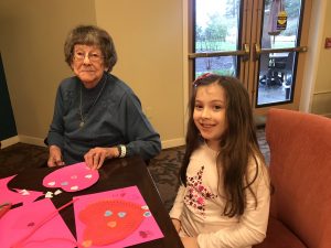 Girl Scouts and Canfield Place resident making Valentine's Day craft